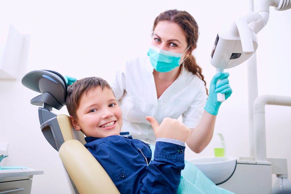 Child With Doctor In The Office Shows Thumb